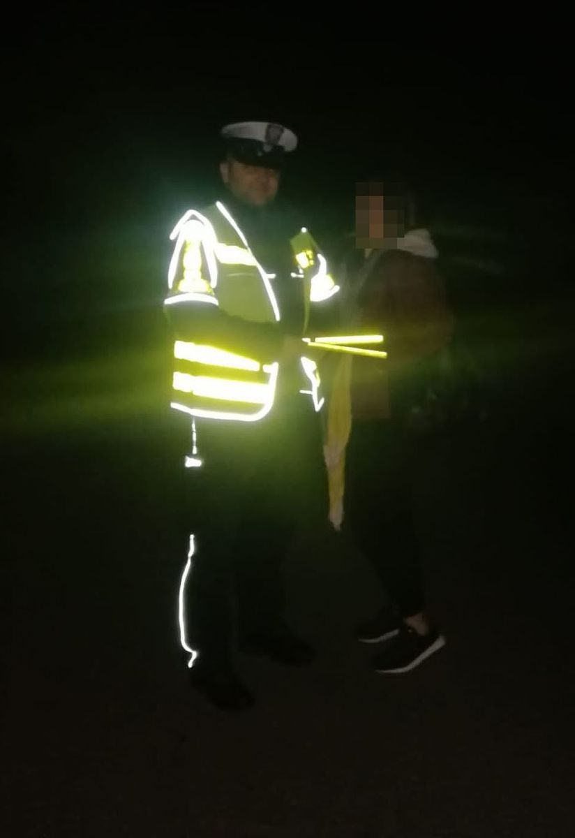 policjant z odblaskami i osobą w ciemnym ubraniu