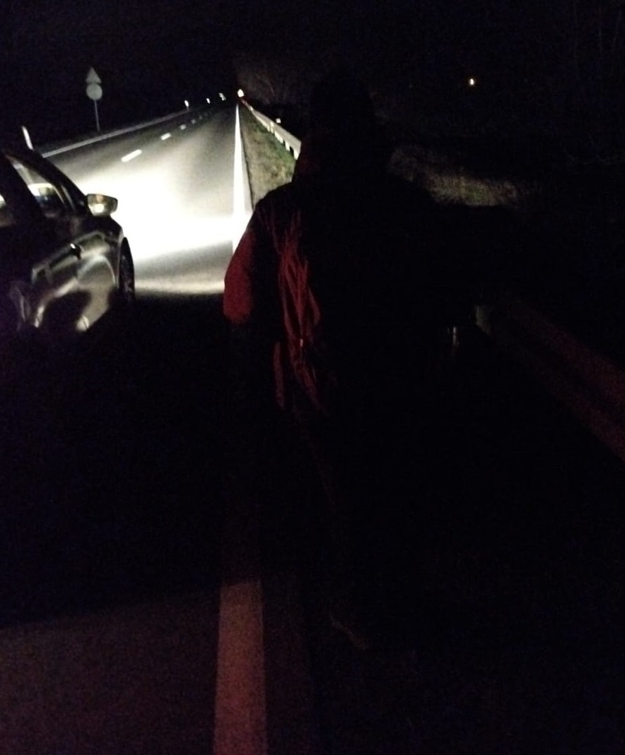 pieszy ubrany na ciemno obok samochód na ulicy