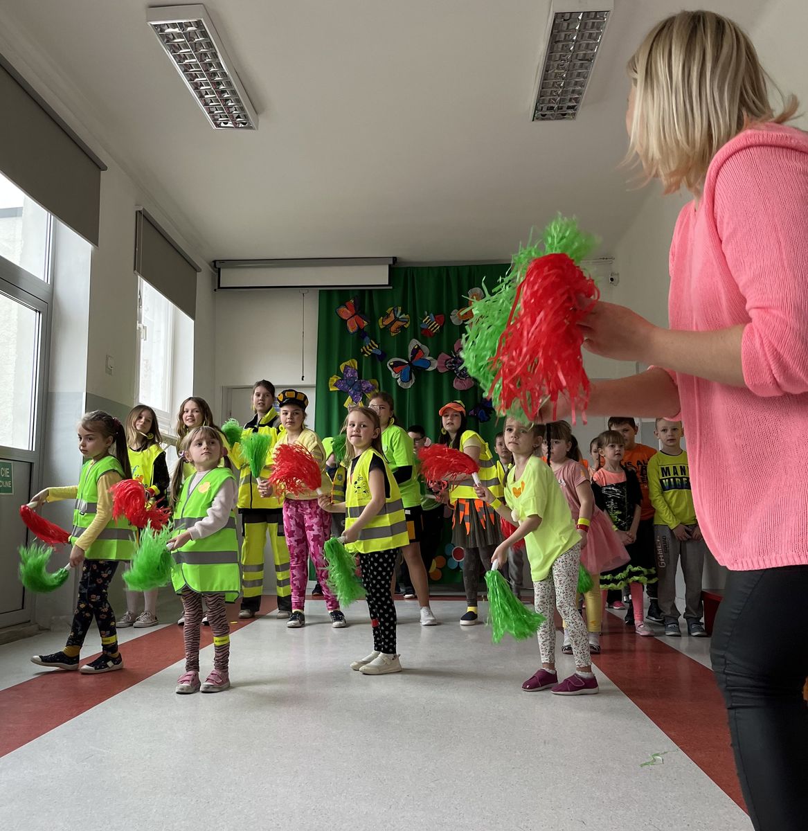 dzieci tańczące z pomponami przed nimi nauczycielka