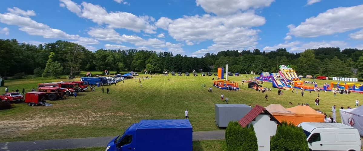 plac za Sanktuarium w Wąwolnicy na nim  wozy służb  dmuchańce
