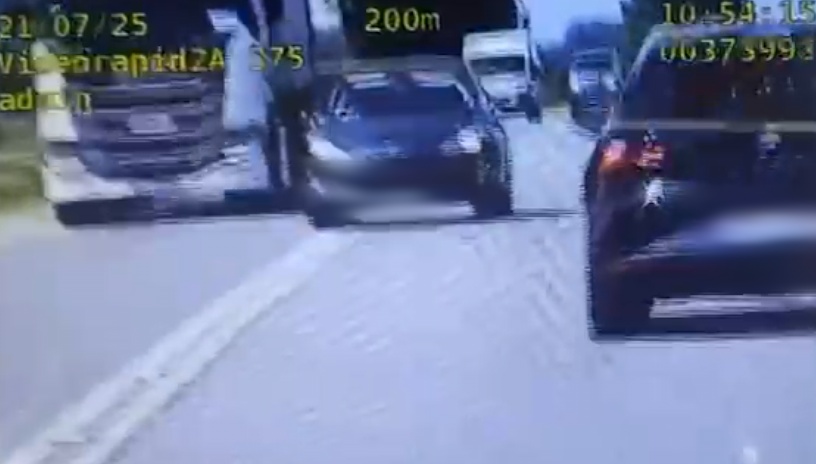 Stop klatka z nagrania policyjnego wideorejestratora na którym widać auto osobowe wyprzedzające inne pojazdy w miejscu zabronionym.  