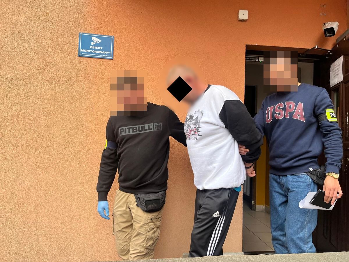 Policjanci prowadzą zatrzymanego.