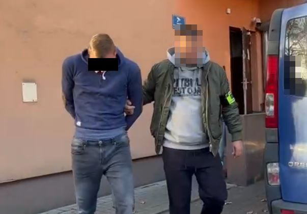 policjant prowadzący zatrzymanego mężczyznę