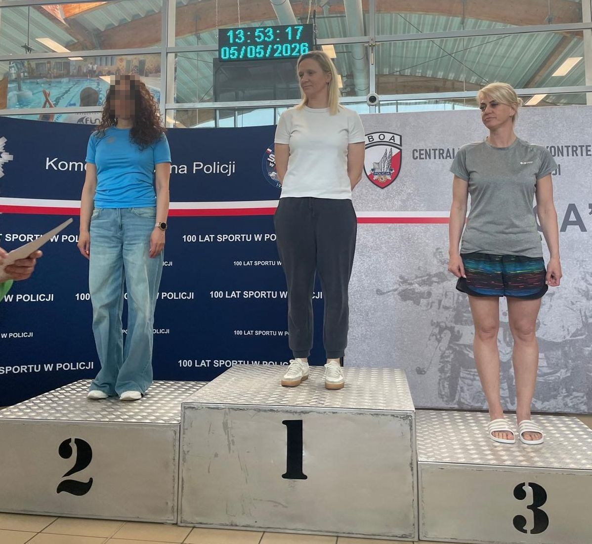 podium z trzema miejscami na każdym z nich kobieta