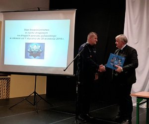 Komendant Powiatowy Policji wręcza album wójtowi