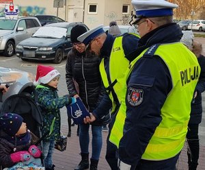 policjant dający dziecku cukierka