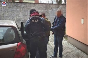 policjanci prowadzą zatrzymanego