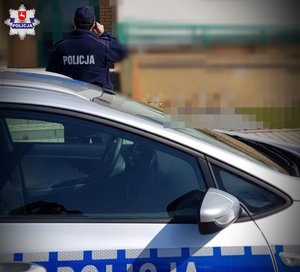 policjant przed blokiem podczas kontroli kwarantanny