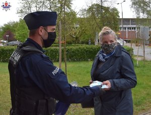 policjant przekazujący maseczkę kobiecie