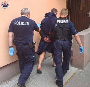 policjanci prowadzą zatrzymanego