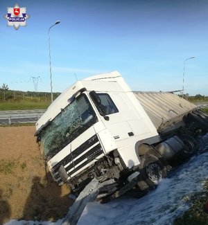 biała ciężarówka leżąca na boku w rowie