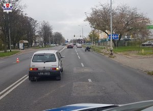 szary fiat na ulicy z rozbitym tyłem przed nim motocykl