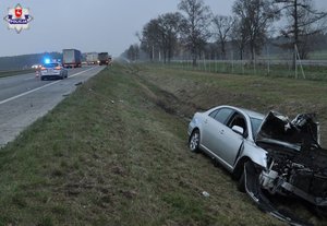 rozbita srebrna toyota w rowie na ulicy ciężarówka w tle radiowóz