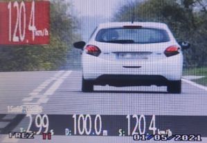 widok z ekranu videorejstratora biały samochód na drodze napis 120 km