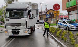 biała ciężarówka na ulicy obok policjantka i radiowóz