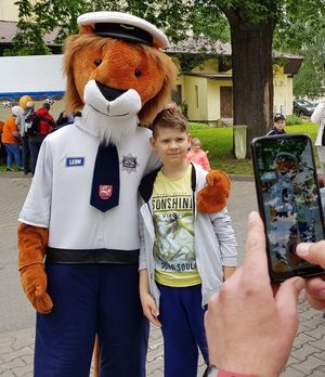 policyjny lew maskotka pozuje do zdjęcia z chłopcem