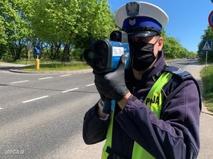 policjant dokonujący pomiaru prędkości na drodze