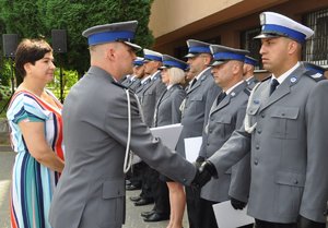 policjant w białej czapce przyjmuje gratulacje od komendanta