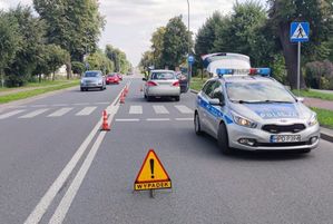 miejsce wypadku radiowóz za nim szara toyota obok niej policjant i dwóch mężczyzn z naprzeciwka jadą 2 samochody