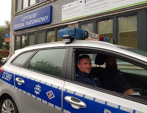 policjanci w radiowozie pod szpitalem