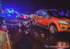 dwa rozbite samochody na szosie pomarańczowy nissan navara i ciemne audi