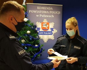 komendant dzielący się opłatkiem z policjantką