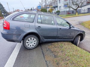 szara skoda kombi stojąca przednimi kołami w rowie