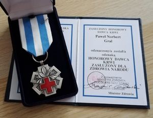 otwarta legitymacja Pawła Norberta Grala odznaczonego odznaką honorowy dawca krwi zasłużony dla zdrowia narodu i medal