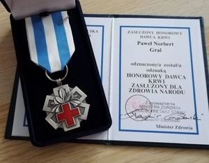 otwarta legitymacja Pawła Norberta Grala odznaczonego odznaką honorowy dawca krwi zasłużony dla zdrowia narodu i medal zajawka