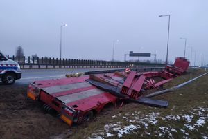 czerwony samochód ciężarowy do wożenia gabarytów stojący w rowie