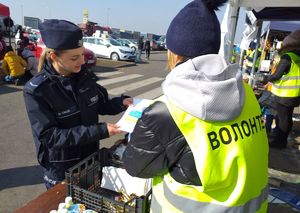 policjantka przekazująca wolontariuszce ulotki