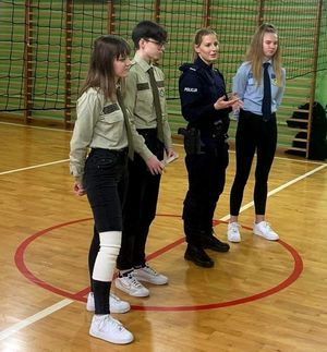 policjantka i uczniowie na sali gimnastycznej