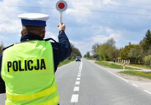 policjant zatrzymujący tarczą samochód