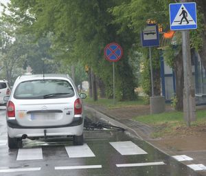 szary citroen stojący za przejściem obok leży rower na jezdni