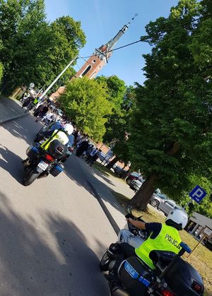policjanci na motocyklach w tle ludzie idący w kierunku kościoła