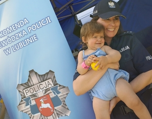 policjantka trzymająca małą dziewczynkę