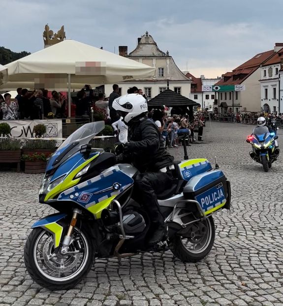 policjanci na motocyklach jadący przez rynek w Kazimierzu wokół kibice wyścigu