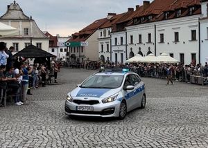 radiowóz policyjny na rynku w Kazimierzu po obu stronach utworzonej drogi stoją ludzie