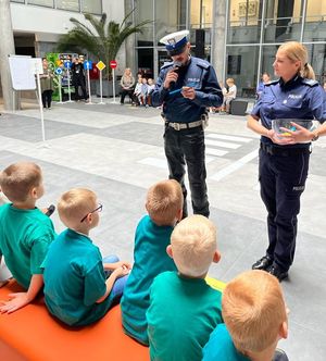 policjant odczytuje pytanie dzieciom obok stoi policjantka