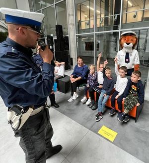 policjant mówiący do dzieci które podnoszą ręce do góry