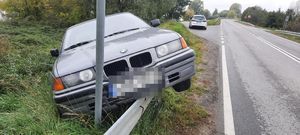 szare BMW zawieszone na barierze