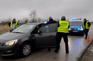 policjanci zatrzymują mężczyznę wysiadającego z samochodu