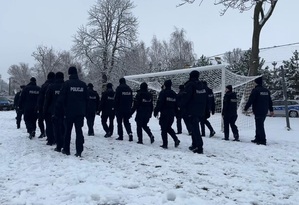 policjanci w trzech rzędach na zaśnieżonym boisku