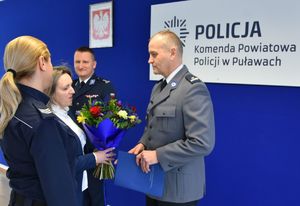 pracownica i policjantka wręczające I Zastępcy kwiaty