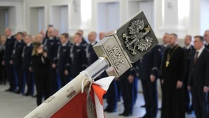 głowiec sztandaru w tle ślubujący policjanci