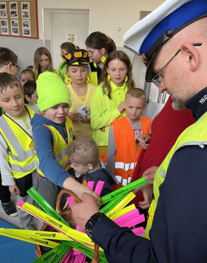 policjant rozdający dzieciom odblaski