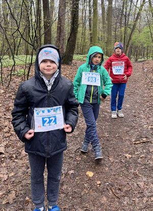 dzieci z numerami startowymi na ścieżce w lesie