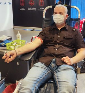 mężczyzna w czarnej koszuli podczas oddawania krwi