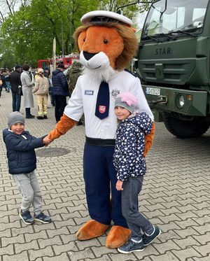 dzieci bawiące się z policyjną maskotką