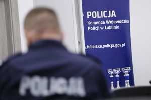 policjanci piszący sprawdzian w tle baner komendy wojewódzkiej policji w Lublinie
